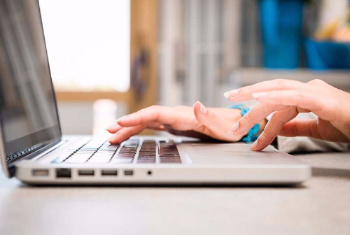 Woman's hands typing on a laptop.