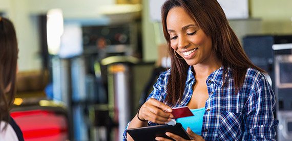 Woman getting her credit card out of her wallet while smiling 