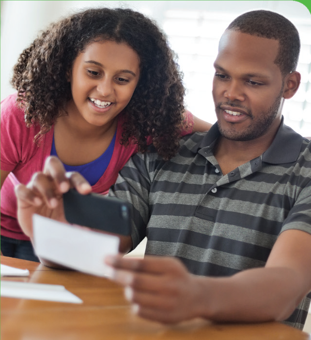 Image of a couple taking a photo of their check with their phone