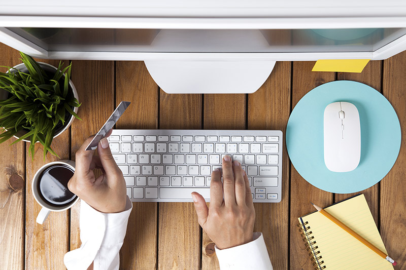 Man on keyboard with credit card and coffee